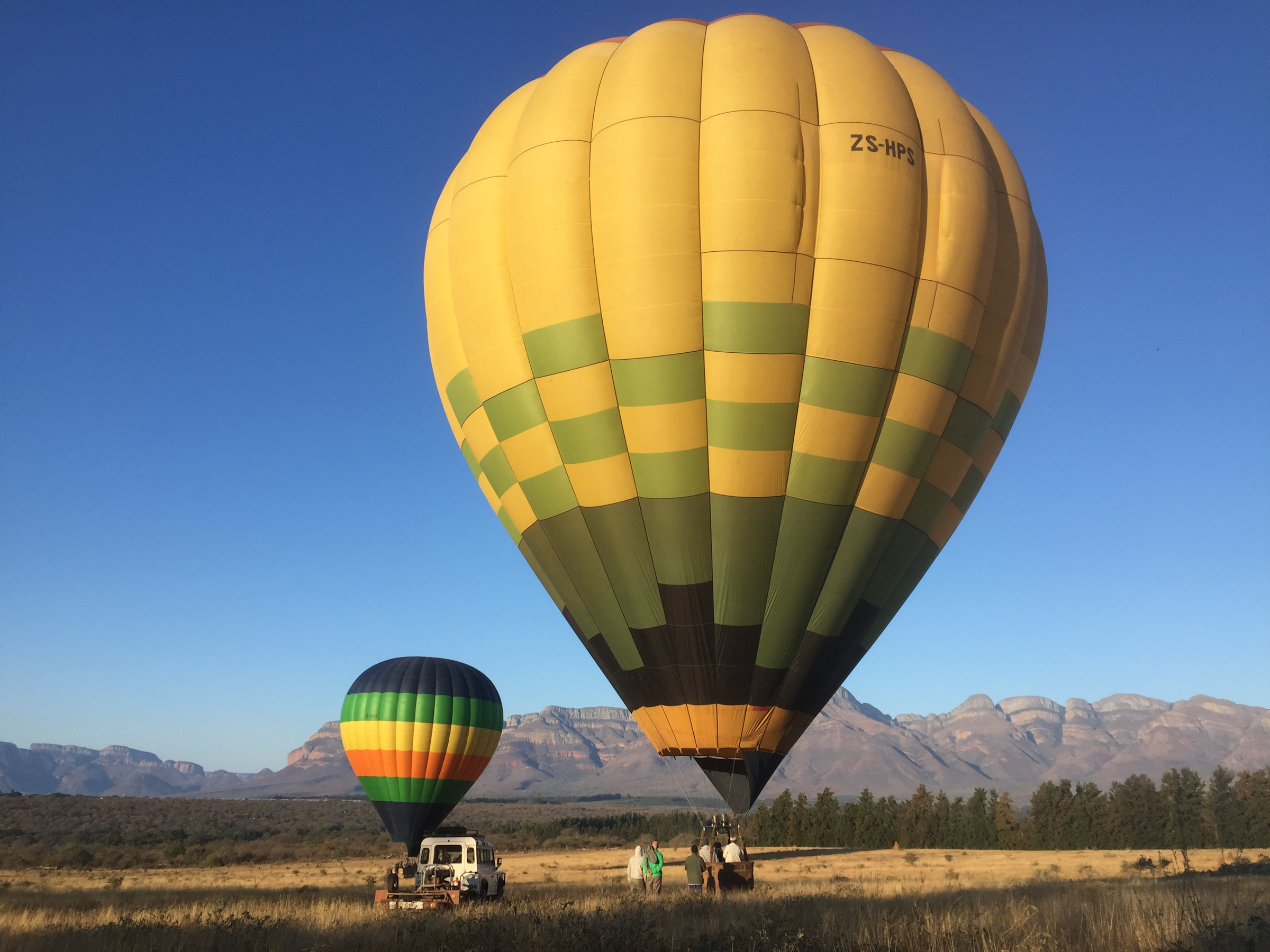 This is an image of two balloons that landed on a farmer's field. The Drakensberg 
            Mountain is visible in the background.