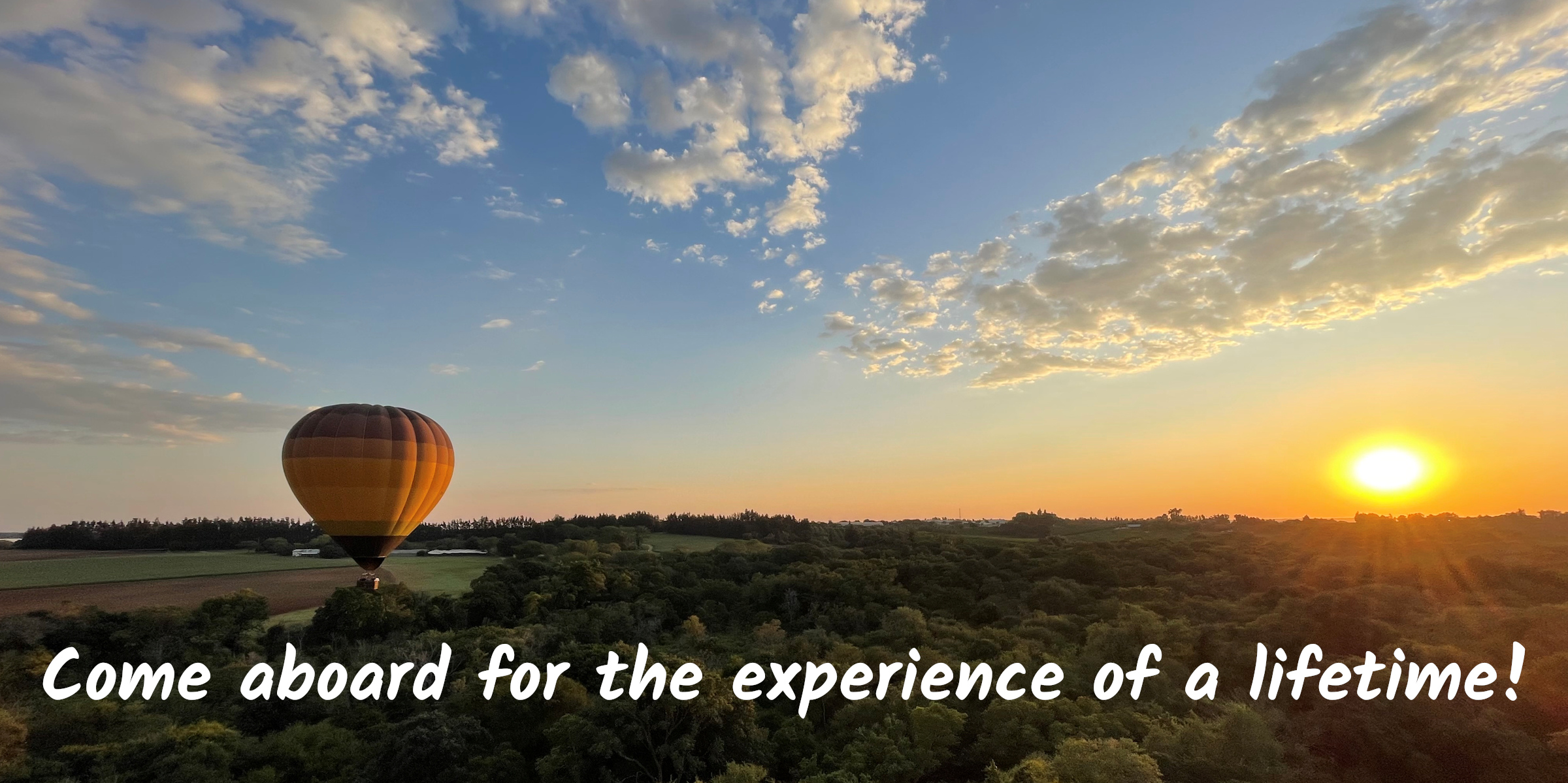 This is an image of a Hot Air Balloon flying. The sunrise is visible in the background.